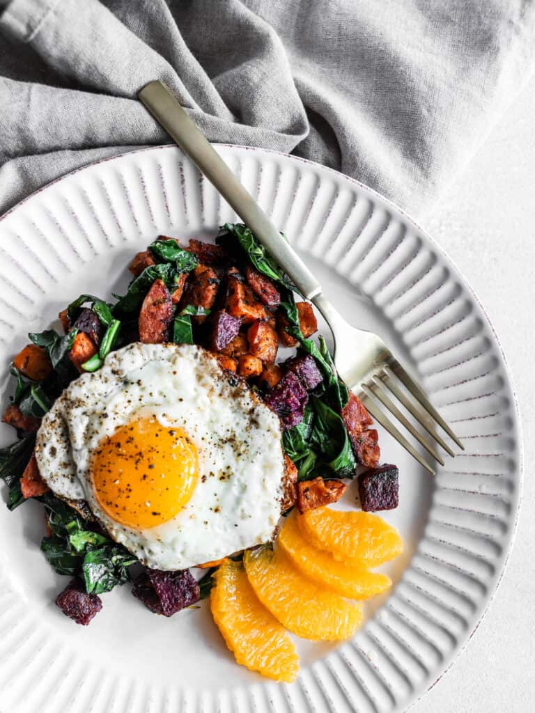breakfast sweet potatoes on a plate with a fried egg on top