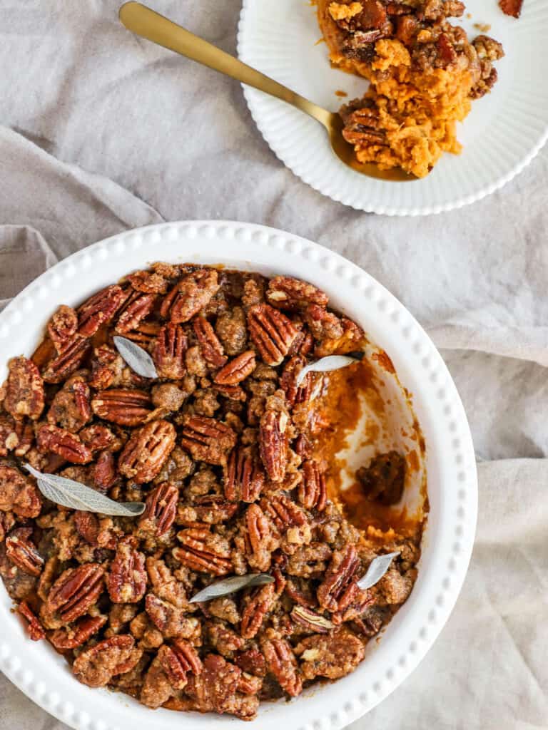 sweet potatoes layered with pecans in a casserole dish