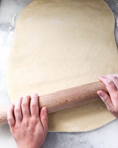 king cake dough getting rolled flat
