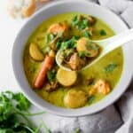 vietnamese chicken curry recipe, Ca Ri Ga, in a bowl with soup spoon and bread on the side