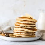 buttermilk pancakes on a plate with a glass of milk