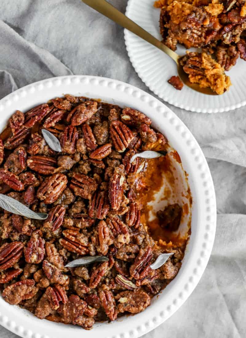 sweet potatoes layered with pecans in a casserole dish