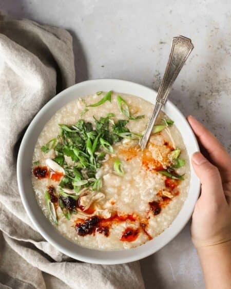 chicken congee in bowl with toppings